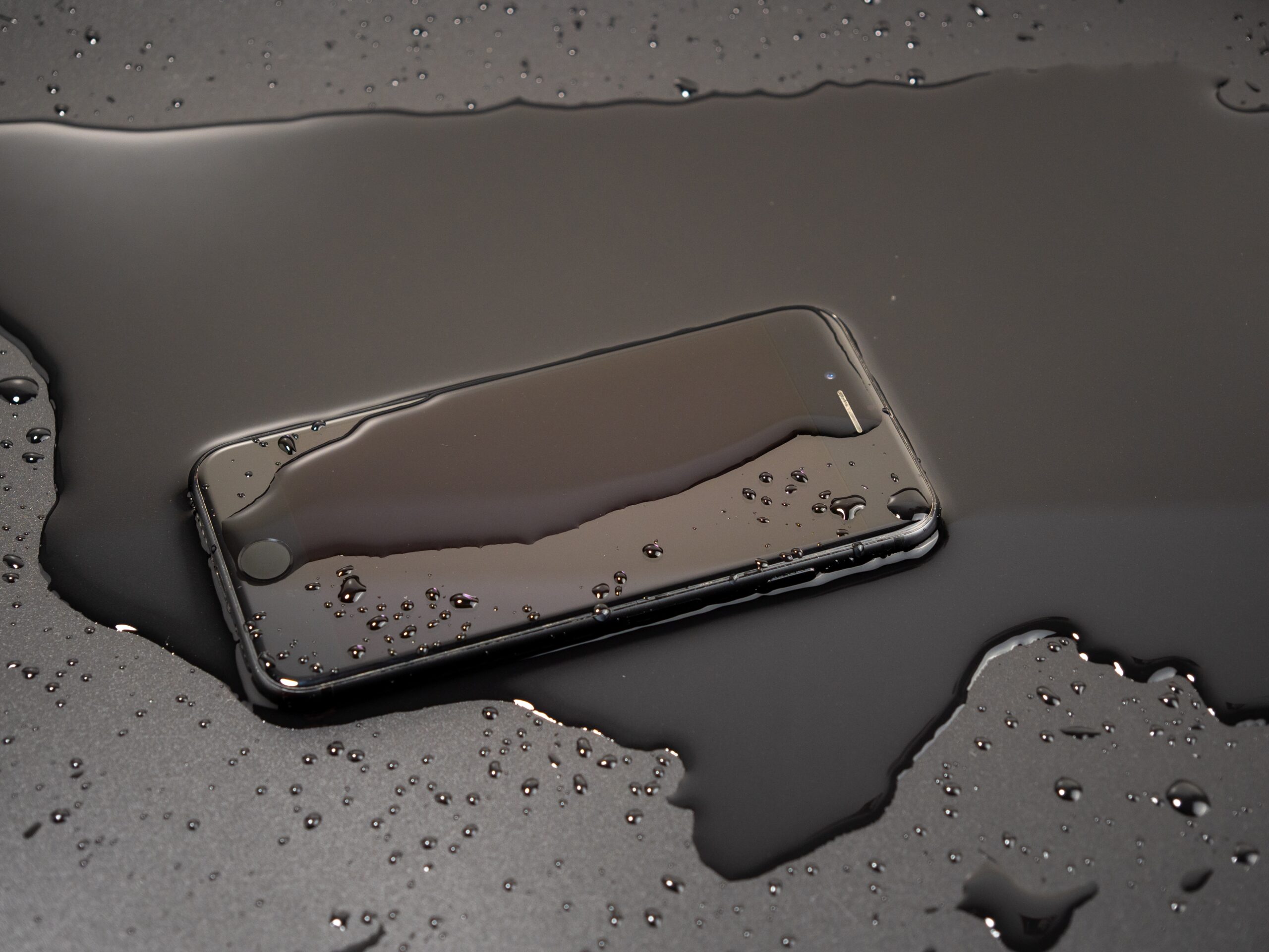 A phone doused in water across a table.